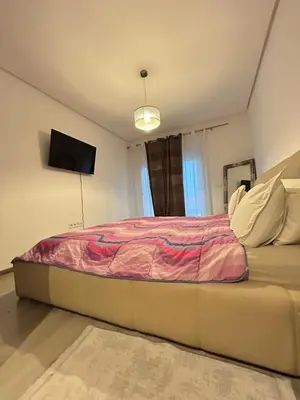 a bedroom with a bed and a tv on the wall at Said in Marrakech