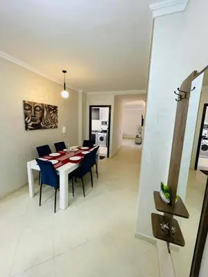 a dining room and kitchen with a table and chairs at Joyau Moderne Appartement in Marrakech