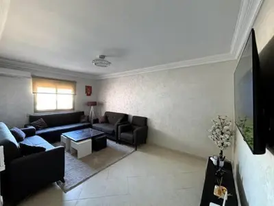 a living room with a couch and a table at Joyau Moderne Appartement in Marrakech