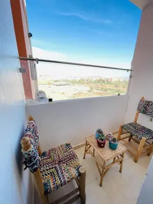 a room with two chairs and a table and a window at Joyau Moderne Appartement in Marrakech