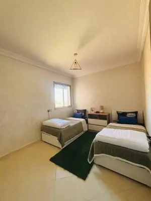 a bedroom with two beds and a window at Joyau Moderne Appartement in Marrakech