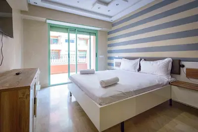 a bedroom with a bed with a striped wall at Appartement Confort - Hivernage - Piscine in Marrakech
