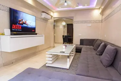 a living room with a couch and a flat screen tv at Appartement Confort - Hivernage - Piscine in Marrakech