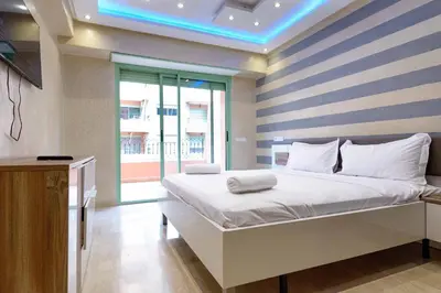 a bedroom with a large bed with a striped wall at Appartement Confort - Hivernage - Piscine in Marrakech