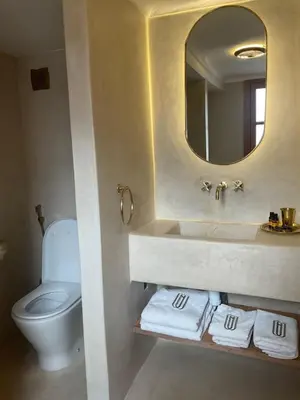 a bathroom with a sink and a toilet and a mirror at Riad Al Muhandiz Peaceful Duplex Suites near Jemaa El Fna in Marrakech