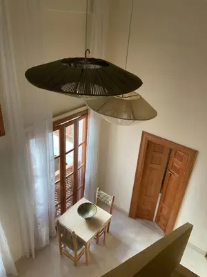 a dining room with a table and a chandelier at Riad Al Muhandiz Peaceful Duplex Suites near Jemaa El Fna in Marrakech