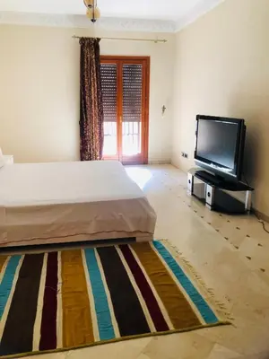 a bedroom with a bed and a flat screen tv at Appartement Ihssane Plaza Kech in Marrakech