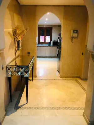 a room with a table with a vase on it at Appartement Ihssane Plaza Kech in Marrakech