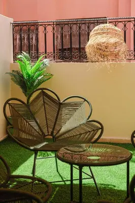 a chair and a table and a plant at apartment gilez in Marrakech