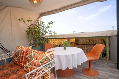 a table and chairs on a porch with a tent at Dar JOMANA in Marrakech
