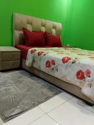 a bedroom with a bed with red pillows and a green wall at Appartement meublé à louer à Marrakech in Marrakech