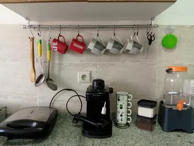 a kitchen counter with cups and utensils on a wall at Appartement meublé à louer à Marrakech in Marrakech