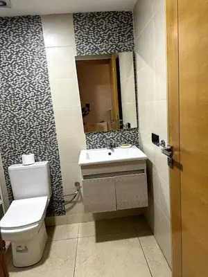 a bathroom with a toilet and a sink and a mirror at Appartement familial moderne et cosy in Marrakech