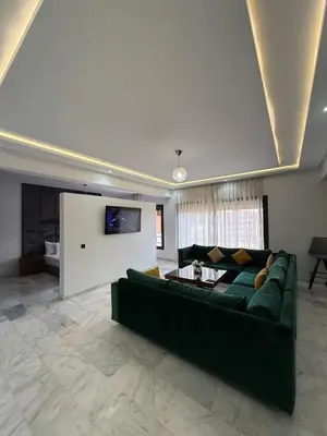 a living room with a green couch and a tv at Marrakech Palm View in Marrakech