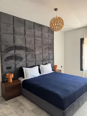 a bedroom with a blue bed with a large headboard at Marrakech Palm View in Marrakech