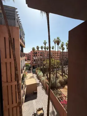 a view of a courtyard with palm trees and buildings at Marrakech Palm View in Marrakech