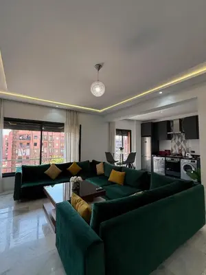 a living room with a green couch and a kitchen at Marrakech Palm View in Marrakech