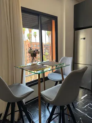 a kitchen with a table and chairs and a window at Marrakech Palm View in Marrakech