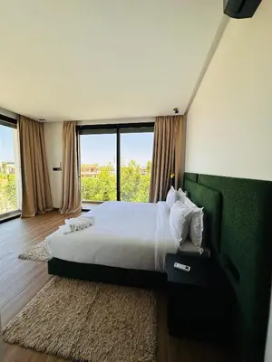 a bedroom with a large bed and a large window at Villa Tiffany NORIA GOLF in Marrakech