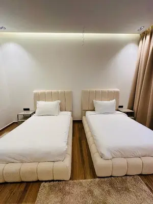 two beds in a room with white sheets at Villa Tiffany NORIA GOLF in Marrakech
