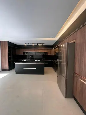 a large kitchen with wooden cabinets and stainless steel appliances at Villa Tiffany NORIA GOLF in Marrakech