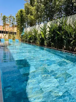 a large swimming pool with blue chairs and trees at Villa Tiffany NORIA GOLF in Marrakech