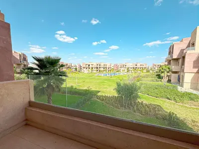 a balcony with a view of a green field at Cocon Prestigia Argan avec piscine & parking in Marrakech