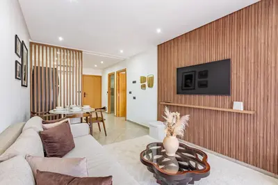 a living room with a couch and a tv on a wall at Modern & cozy apartment in Marrakech