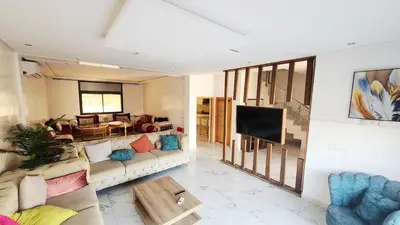 a living room with a couch and a tv at Villa with private pool in Marrakech