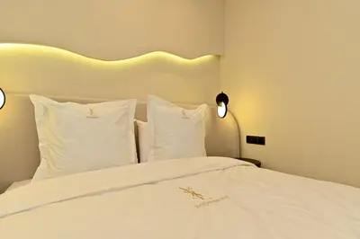 a bed with white sheets and pillows in a room at Luxurious colorful apartment in Marrakech