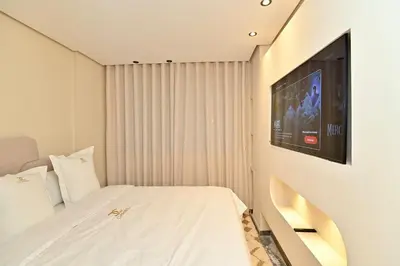 a bedroom with a bed and a tv on the wall at Luxurious colorful apartment in Marrakech
