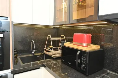 a microwave in a kitchen with a red appliance on it at Luxurious colorful apartment in Marrakech