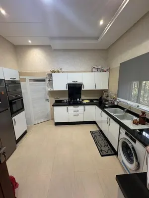 a large kitchen with white cabinets and appliances at Villa avec piscine privé in Marrakech
