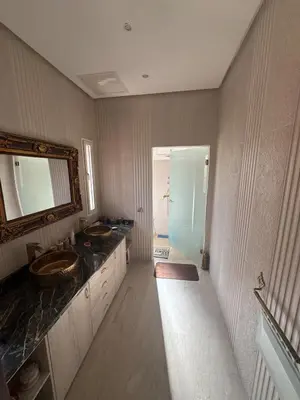 a bathroom with two sinks and a mirror and a shower at Villa avec piscine privé in Marrakech
