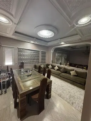 a dining room with a table and a couch at Villa avec piscine privé in Marrakech