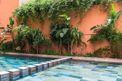 a swimming pool in front of a wall with plants at La Perle - Semlalia Gueliz - 2 Prs - Balcony in Marrakech