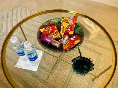 a glass table with a bowl of chips and water at TERRASSE, 2 CHAMBRES SPACIEUSES, 6 COUCHAGES, 2 PiSCINES, PARKING, IDÈAL FAMILLE in Marrakech
