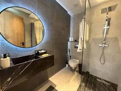 a bathroom with a sink and a toilet and a mirror at TERRASSE, 2 CHAMBRES SPACIEUSES, 6 COUCHAGES, 2 PiSCINES, PARKING, IDÈAL FAMILLE in Marrakech