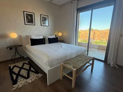 a bedroom with a large bed and a large window at TERRASSE, 2 CHAMBRES SPACIEUSES, 6 COUCHAGES, 2 PiSCINES, PARKING, IDÈAL FAMILLE in Marrakech