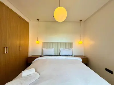 a bedroom with a large white bed with two pillows at RESIDENCE PRESTIGIA, Piscine, calme et verdure in Marrakech