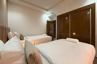 a hotel room with two beds with white sheets at Two Bedroom Apartment with Pool in Marrakech