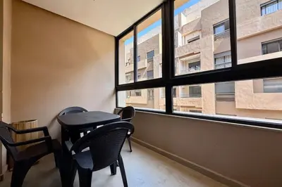 a table and chairs in a room with a window at Two Bedroom Apartment with Pool in Marrakech