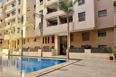 an apartment building with a swimming pool in front of a building at Two Bedroom Apartment with Pool in Marrakech