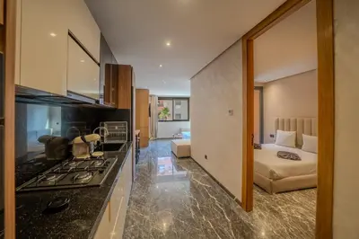a kitchen with a stove top oven next to a bedroom at appartement Confort & modernité au centre de Marrakech in Marrakech