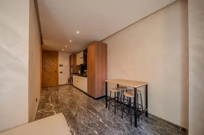 a small kitchen with a table and stools in a room at appartement Confort & modernité au centre de Marrakech in Marrakech