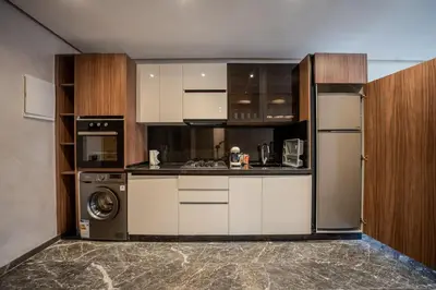 a kitchen with white cabinets and a washer and dryer at appartement Confort & modernité au centre de Marrakech in Marrakech