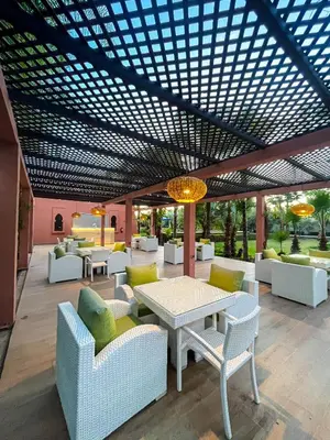 a patio with white chairs and tables and a roof at Complexe villa and Restaurant in Marrakech