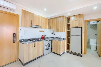 a kitchen with wooden cabinets and a washer and dryer at Nouvel 1 chambre proche centre in Marrakech