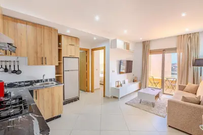 a kitchen and living room with a stove and refrigerator at Nouvel 1 chambre proche centre in Marrakech