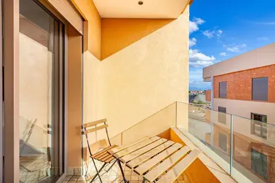 a wooden chair sitting on a balcony with a window at Nouvel 1 chambre proche centre in Marrakech